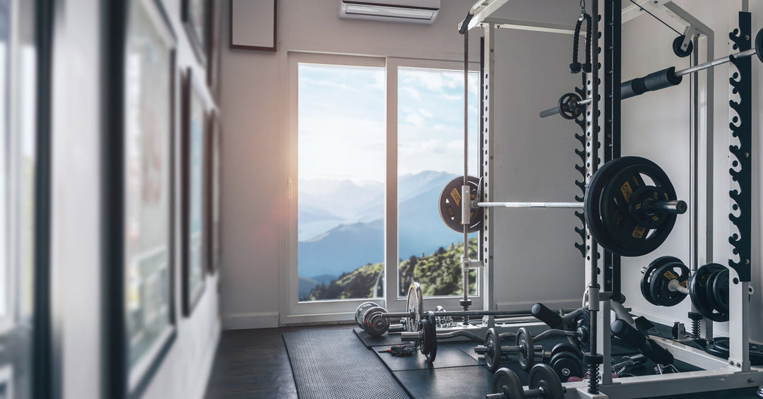 A personal gym space with equipment and mats, a window, and a mini-split system mounted to the wall.